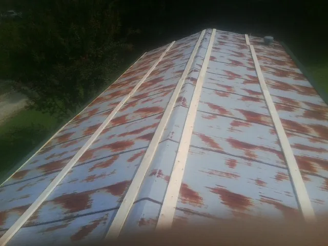 Rusted metal roof panels with new wood purlins before replacement — Storm Damage Roof Repair in Glouster by Roofing Brothers