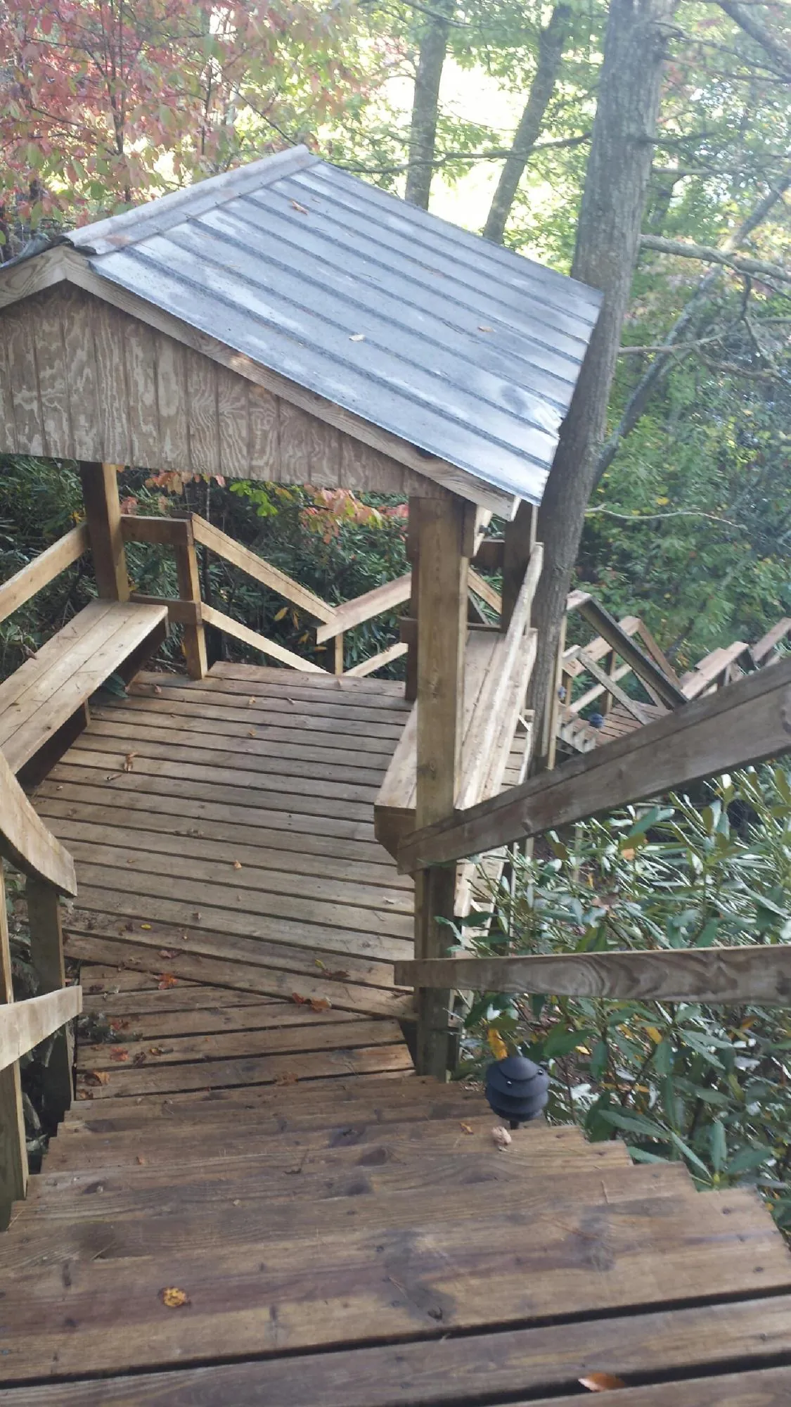 Metal roofed shelter over wooden steps on a wooded walkway — Skylight Repair & Installation work by our crew in Glouster