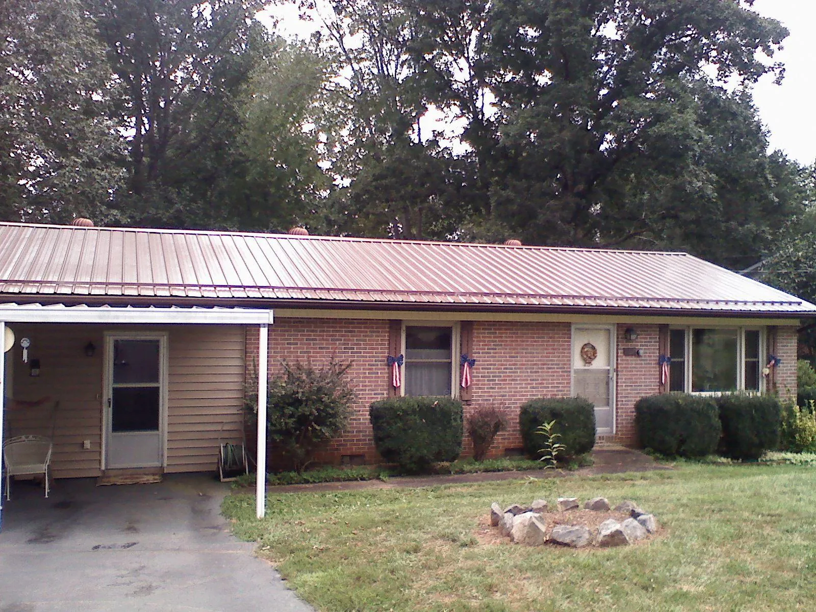 Bronze metal roof and carport on a brick ranch home — Roof Repair work by our crew in Glouster